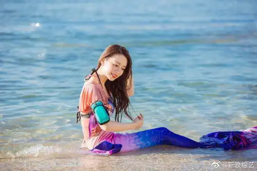 组图吉娜着美人鱼泳装凸显好身材海边侧卧玩耍笑容灿烂
