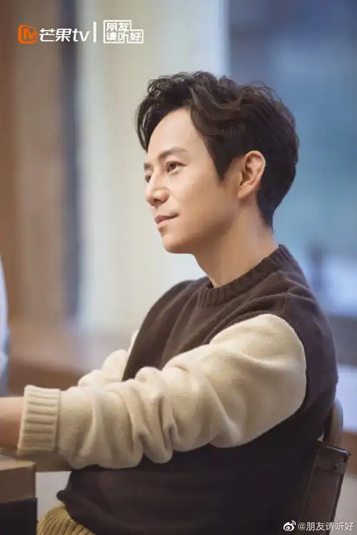 组图何炅穿卡其色拼接毛衣文艺范足逗弄小猫眼神温柔