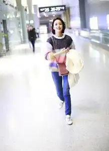 佟丽娅身穿彩虹毛衣打扮青春,俏皮撩发露出笑容甜美十足
