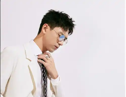 李现早期学车照,黑色背心搭短裤,皮肤晒得黝黑人群中满脸笑意
