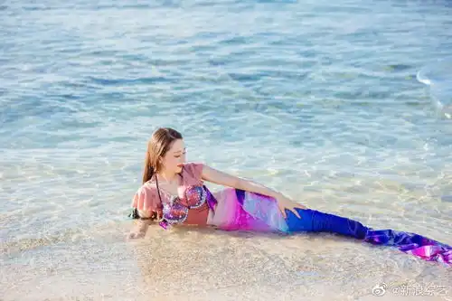 组图吉娜着美人鱼泳装凸显好身材海边侧卧玩耍笑容灿烂
