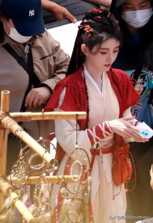 鞠蜻讳现身仙剑奇侠传4横店片场,身穿粉色戏服手拿冰袋降温

