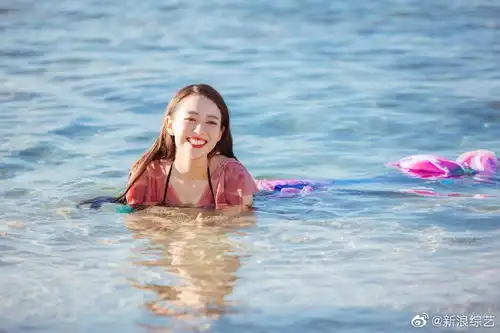 组图吉娜着美人鱼泳装凸显好身材海边侧卧玩耍笑容灿烂
